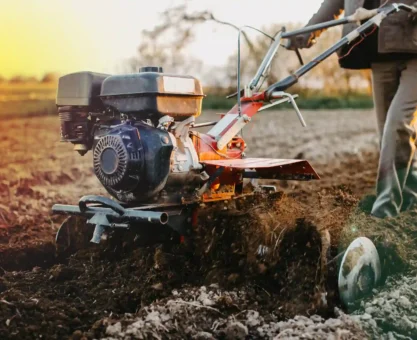 Imagem de uma pessoa utilizando uma máquina agrícola para preparo do solo, ideal para ilustrar o funcionamento de soft starter em equipamentos industriais.