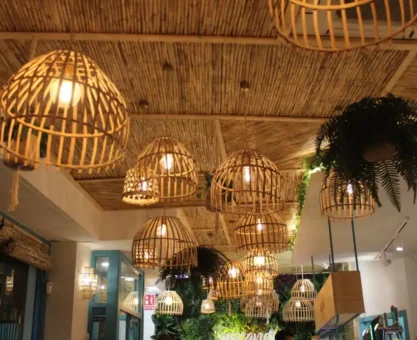 Elegantes lustres pendentes de fibra natural decorando o teto de um ambiente interno aconchegante, com iluminação suave e plantas decorativas ao redor.