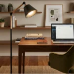 Imagem de um escritório em casa com uma mesa de madeira, um laptop aberto, uma luminária de piso e prateleiras com livros e plantas decorativas, ideal para trabalhar de forma confortável e organizada.