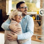 Mãe e filho se abraçando com alegria em ambiente acolhedor, transmitindo amor e conexão familiar, ideal para temas de carinho e relacionamento familiar. Para conteúdo sobre o que comprar para dia das mães