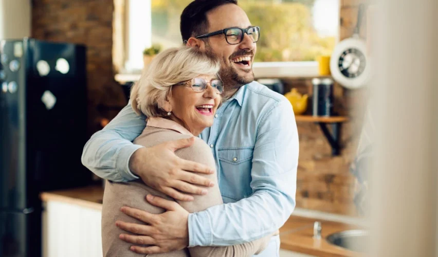 Mãe e filho se abraçando com alegria em ambiente acolhedor, transmitindo amor e conexão familiar, ideal para temas de carinho e relacionamento familiar. Para conteúdo sobre o que comprar para dia das mães